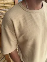 Remera beige de algodón con cuello redondo y mangas cortas.
