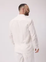 Camisa celeste de lino, de manga larga, con cuello abotonado y bolsillo en el pecho.