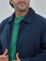 Campera azul marino de poliéster, manga larga con cierre de cremallera, dos bolsillos inferiores y logo de Tommy Hilfiger bordado en el pecho.