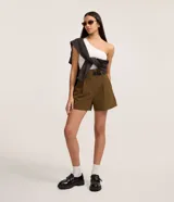 Short sastre de corte recto y cintura alta color verde militar, con pinzas delanteras, trabillas para cinturón y cierre frontal oculto. Incluye un medio cinturón lateral de poliuretano con hebilla.