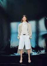 Blusa de manga larga con diseño de rayas verticales, cuello redondo y pañuelo integrado al tono. Presenta un corte recto y cierre de botón en la parte posterior.