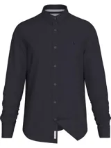 Camisa de vestir azul marino, corte slim, con cuello abotonado, cierre con botones y mangas largas. Presenta un mini monograma bordado en el pecho y logo de Calvin Klein Jeans en la parte inferior.