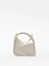 Bolso de cóctel en color blanco roto con estructura rígida y diseño geométrico. Cuenta con un asa tubular corta integrada y una correa larga extraíble. Presenta cierre magnético y un compartimento principal.