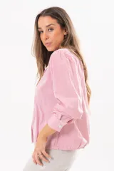 Camisa de manga larga con diseño a rayas rojas y blancas, cuello camisero y cierre frontal con solapa.