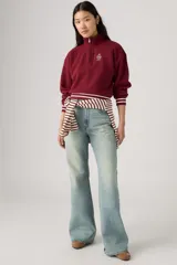Jean de corte flare y tiro medio en tono celeste claro, con acabado deslavado y diseño clásico de cinco bolsillos.