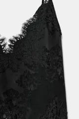 Top largo confeccionado en tejido de encaje con escote en pico y tirantes finos. Presenta una combinación de tejidos a tono con diseño sofisticado.