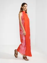 Vestido largo halter color naranja con estampado floral en rosado, confeccionado en tejido liviano.