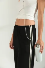 Pantalon de jogging de corte amplio y tiro medio, color gris melange, con cintura elástica y detalle de franjas laterales en tono claro.