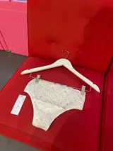 Bombacha de tiro alto confeccionada en encaje blanco con diseño floral, de calce vedetina.