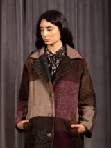 Chaquetón largo de paño con diseño de cuadros en tonos tierra, borravino y negro. Presenta cuello solapa, bolsillos laterales y forro interior.