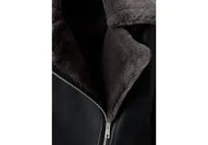 Chaqueta estilo aviador de color negro con interior de piel sintética gris oscuro, cierre frontal cruzado con cremallera y solapas grandes.