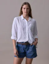 Camisa de lino marca Dash, color blanco, de manga larga regulable, con cuello camisero, cierre frontal con botones y bolsillo aplicado en el pecho.