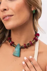 Collar corto con cuentas cilíndricas de cerámica jaspeada y discos de madera, con un gran dije central de resina en forma trapezoidal.