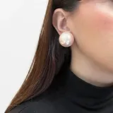 Aros cortos de perla esférica con acabado brillante y diseño voluminoso, con sistema de ajuste mediante clip.