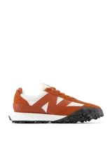 Championes New Balance color naranja con detalles en blanco y negro.