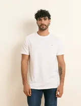 Remera básica de algodón color beige, de manga corta, con cuello redondo y un pequeño detalle bordado en el pecho.