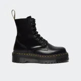 Botas de caña alta estilo militar Dr. Martens modelo Jadon, confeccionadas en piel negra con acabado brillante. Presentan cierre de cordones, suela de plataforma dentada con costuras amarillas características y tirador trasero con logo.