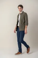 Sobre camisa color verde militar de lino con cuello clásico, manga larga con puños abotonados, cierre frontal con botones a tono y bolsillos de parche en el pecho.