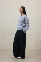 Suéter de punto color beige claro jaspeado, de corte holgado y cuello redondo. Presenta un tejido de punto acanalado en el cuello, puños y bajo.