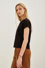 Remera de algodón color marrón oscuro con escote en V y dos apliques bordados en forma de corazón en el frente.