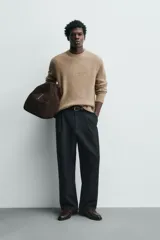 Sweater de punto color beige, de corte relajado, con cuello redondo y diseño texturizado en estructura waffle.
