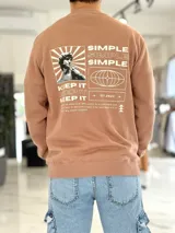 Buzo color camel de corte clásico, con cuello redondo, mangas largas y estampa gráfica en la espalda con diseño de arte clásico, el texto "Simple" y "Keep it".