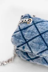 Cartera bandolera de jean negro con diseño acolchado en forma de rombos. Tiene correa de cadena plateada y manija de jean.