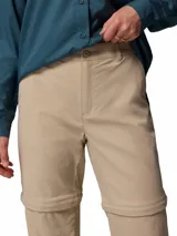 Pantalón Columbia de trekking convertible en bermuda, modelo Leslie Convert Pant Omni-Shade, color beige, con perneras desmontables mediante cremallera, bolsillos laterales y tecnología de protección solar.