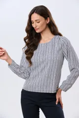 Blusa clásica de manga larga en color blanco, con cuello redondo y diseño fluido.