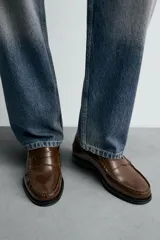 Mocasín de vestir fabricado en piel con acabado brillante, presenta detalle de antifaz en el empeine, plantilla de piel y suela a contraste con ligero tacón.