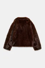 Cazadora reversible de corte recto, con cuello de solapa, manga larga y cierre frontal con botones. Presenta un exterior efecto ante y un interior con acabado de pelo sintético, incluyendo detalles de pelo en los bordes.