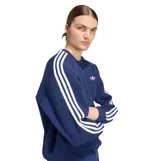 Buzo Adidas de cuello redondo en color azul, con diseño oversize y ajuste relajado. Presenta el logo Trefoil bordado en el pecho y las icónicas tres tiras blancas en las mangas.