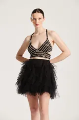 Falda corta negra con múltiples capas de tul fruncido que aportan volumen y movimiento.
