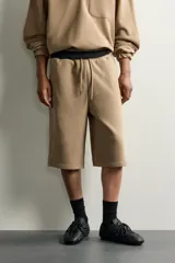 Bermuda estilo jogger de ajuste relajado, color beige, con cintura elástica ajustable mediante cordón y bolsillos delanteros.