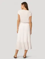 Falda larga de crepé de rayón color blanco, con diseño de paneles escalonados y detalles de puntilla. Presenta una silueta holgada y cintura elástica.