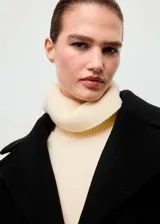 Abrigo de lana de corte oversize, color negro, con cuello de solapa con muesca, cierre frontal de botones y manga larga. Cuenta con forro interior.