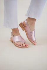 Sandalias de cuero color rosa metalizado, con puntera descubierta, tira ancha sobre el empeine y tira trasera con hebilla.