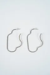 Aros tipo argolla con diseño abstracto y forma irregular, confeccionados en metal plateado con textura trenzada.