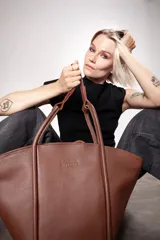 Bolso tote de cuero color marrón con doble asa de mano.