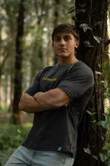 Remera gris oscuro de manga corta raglán, confeccionada en algodón. Presenta costuras a la vista en color amarillo.