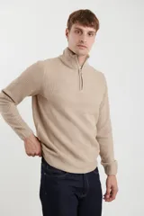 Sweater verde de punto inglés con cuello alto y cierre metálico frontal. Tiene mangas largas y terminaciones en punto canalé.