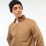 Camisa de manga larga color marrón claro, con cuello clásico, un bolsillo de parche en el pecho izquierdo y botones frontales.