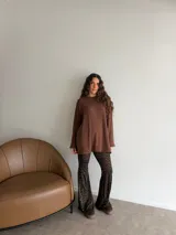 Conjunto compuesto por un buzo de punto acanalado en color beige con cuello redondo y mangas largas holgadas, y un pantalón tipo oxford de tiro alto con estampado animal print de leopardo.
