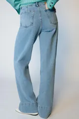 Jeans de tiro alto con corte wide leg y pernera ancha. Presenta bolsillos de plastrón en el delantero y cierre frontal con cremallera y botón.