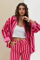 Campera de denim con diseño de rayas verticales en tonos rojo y rosado, cuello clásico, cierre frontal con botones metálicos y bolsillos appliqued en el frente.