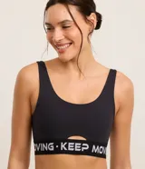 Top deportivo azul con breteles anchos, copas desmontables, recorte en el busto y banda elástica inferior color borgoña con letras blancas.