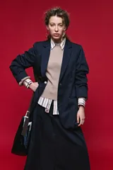 Blazer azul marino con cuello alto y cierre frontal cruzado.