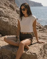 Short de lino color azul marino, de tiro alto, con bolsillos laterales y e incluye un cinto de rafia con hebilla redonda.