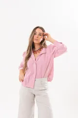 Camisa de manga larga con diseño a rayas rojas y blancas, cuello camisero y cierre frontal con solapa.
