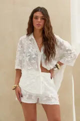 Short blanco con bordados florales y detalles de encaje en el ruedo.